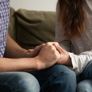 Close up view of couple holding hands, loving wife supporting or comforting husband ready to help expressing sympathy, encouraging and understanding in marriage relationships, reconciliation concept